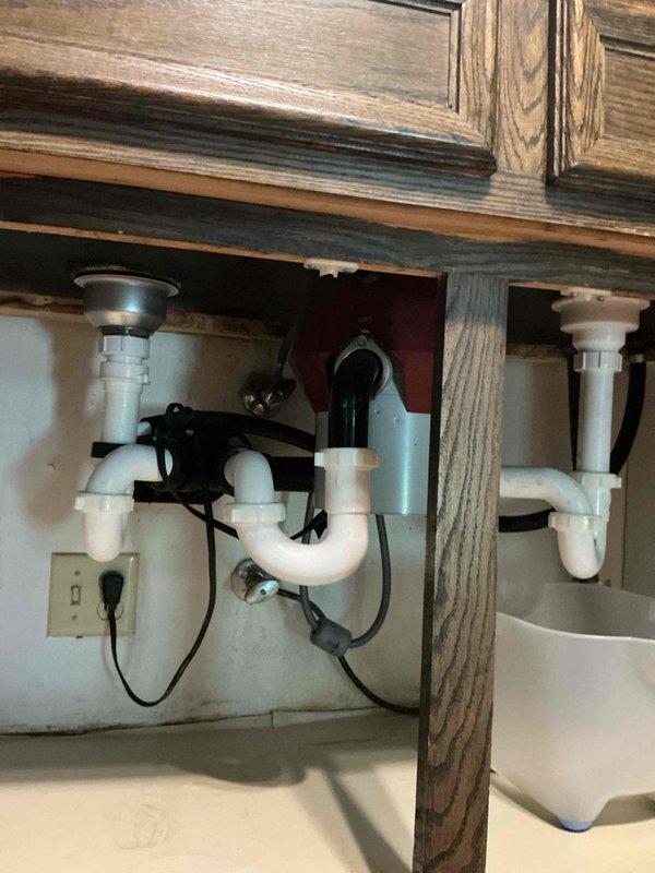 Responded to service call for kitchen sink backing up and not draining properly. Upon arrival, performed diagnostic inspection and identified blockage caused by accumulation of food debris, soap scum, and sludge restricting the drain line. Utilized flex shaft cable machine to clear the obstruction, running the cable through the full length of the drain line while flushing with hot water to break up buildup. Located and cleared the blockage at approximately 15 feet into the line, successfully restoring proper drainage flow. Reassembled all drain components and conducted thorough testing by filling and dumping both sink bays to verify complete clearance. Confirmed all drainage functioning properly with no leaks detected at any connections. System restored to full working order.