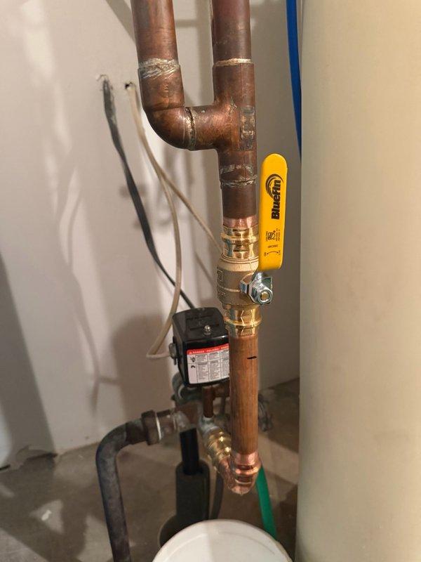 Responded to water leak on water softener line caused by failed solder joint on main line ball valve. Removed defective valve, prepared copper pipe connections, and installed new brass ball valve with proper soldering techniques to ensure leak-free operation. Tested system under pressure to verify repair integrity and confirmed no additional leaks in surrounding plumbing assembly.