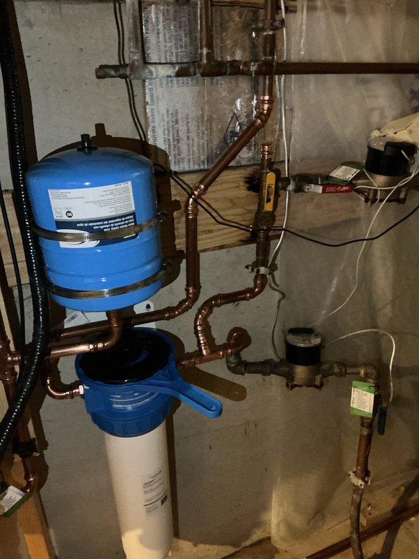Responded to service call for banging noises in plumbing system associated with tankless water heater operation. Upon inspection, identified severely clogged water filter as primary cause of water hammer and pressure fluctuations. Removed and cleaned filter housing, confirmed hot water system remained operational throughout service. Diagnosed irrigation line routing conflict that was contributing to pressure issues at filter location. Rerouted irrigation line to bypass filter assembly, eliminating interference with main water supply system. Tested all connections for leaks, verified proper water pressure restoration throughout system, and confirmed elimination of banging noises during water heater operation.