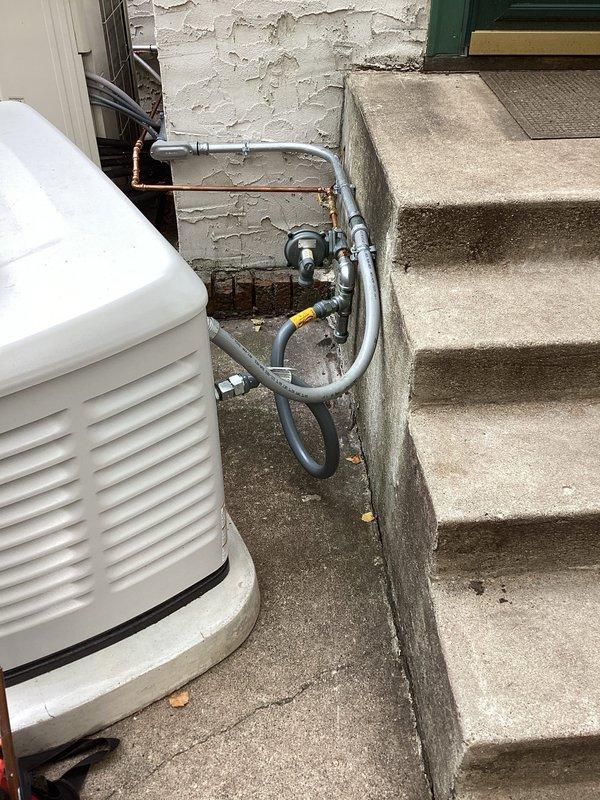 Completed callback to correct gas piping installation to residential generator. Removed and replaced non-compliant black iron piping with code-approved materials, installed new gas regulator in improved location for proper clearances and accessibility, and replaced existing gas whip with correct specification flexible connector. Repositioned gas meter assembly and modified piping configuration to meet current code requirements, ensuring proper support and routing of all gas lines from meter to generator unit.