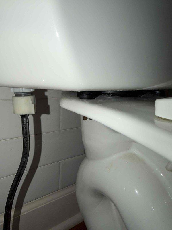 Responded to report of leaking upper-level toilet. Upon investigation, identified the source of the leak as loose tank-to-bowl bolts rather than a failed tank-to-bowl gasket as initially suspected. Tightened the tank-to-bowl mounting bolts to manufacturer specifications, resolving the leak. Documented toilet make and model and confirmed proper seal integrity after adjustment.