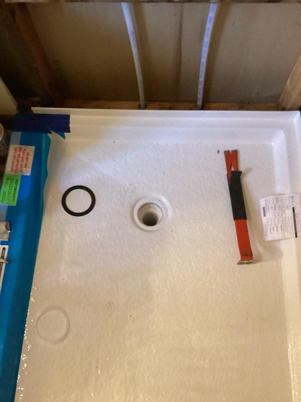 Completed installation of Moen shower valve and drain assembly in bathroom renovation area. Installed rough plumbing components including vertical PVC drain lines secured to horizontal backing boards with proper fasteners. Set shower drain fitting with gasket in fiberglass shower basin and connected to drainage system. All plumbing rough-in work completed per manufacturer specifications and ready for wall finishing and trim-out phase.