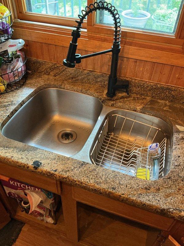 Responded to service call for kitchen drain stoppage and two leaking outdoor hose bibs. Upon diagnostic inspection, confirmed kitchen sink was backing up and required cabling, and both exterior hose spigots exhibited dripping when water was turned on. Cabled kitchen sink drain to full cable length, successfully clearing the blockage and extracting a large amount of debris from the drain line. Reassembled drain components and performed operational testing to verify proper drainage and confirm no leaks were present. Customer declined to proceed with hose bib replacement at this time.