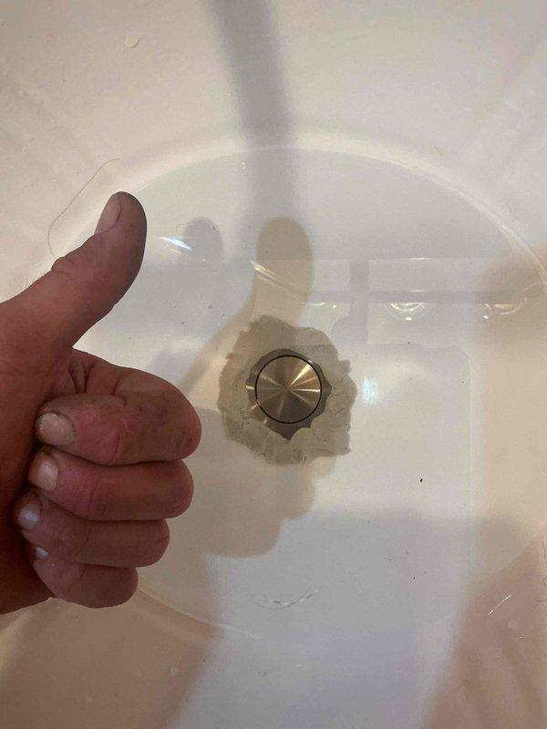 Responded to callback for basement bathroom sink pop-up assembly installation. Initial installation attempt failed water retention test due to faulty gasket seal. Retrieved replacement parts from warehouse, properly lubricated new pop-up gasket, and reinstalled brushed nickel pop-up drain assembly. Conducted water flow test to verify proper seal and drainage function, confirming successful repair completion.