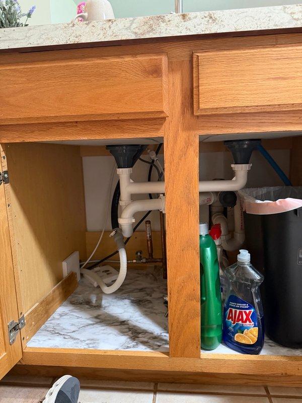 Responded to callback for dirty water accumulating in dishwasher following garbage disposal removal. Upon inspection, identified that dishwasher drain line lacked proper high loop configuration, allowing wastewater to siphon back into the appliance. Installed proper high loop on dishwasher drain line under sink to prevent backflow and ensure complete drainage from the line. Tested system to verify proper operation and drainage.