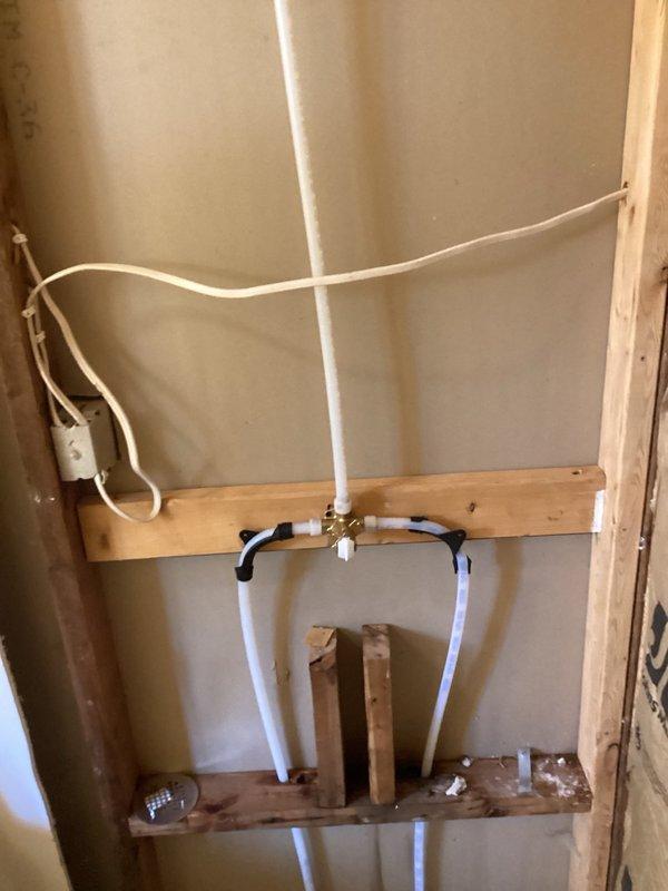 Responded to callback regarding shower valve cartridge installation and water line testing concerns. Installed shower valve cartridge and completed plumbing rough-in work with PVC supply lines properly secured to wooden blocking between wall studs using appropriate clamps and straps. Configured water supply lines in U-shaped loop configuration to accommodate valve placement. All plumbing lines properly supported and ready for pressure testing per code requirements.
