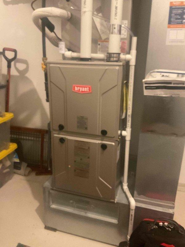 Responded to service call for 6-year-old Bryant furnace experiencing intermittent shutdowns during cold weather with blinking diagnostic light and water accumulation in condensate pan. Upon inspection, homeowner reported water leaking into blower assembly during winter operation and requested camera inspection of PVC condensate drain system to identify potential blockages or improper pitch in piping. Performed visual inspection of furnace unit and traced accessible portions of condensate drain lines in apartment building installation. Documented current system configuration with photographs including furnace cabinet, condensate drain piping with trap, and exhaust venting routing. Determined that comprehensive camera inspection of drain system was necessary but could not be completed during this visit due to extended pipe runs throughout multi-unit building structure requiring specialized equipment. Coordinated with management to obtain building layout and piping schematics to plan foll