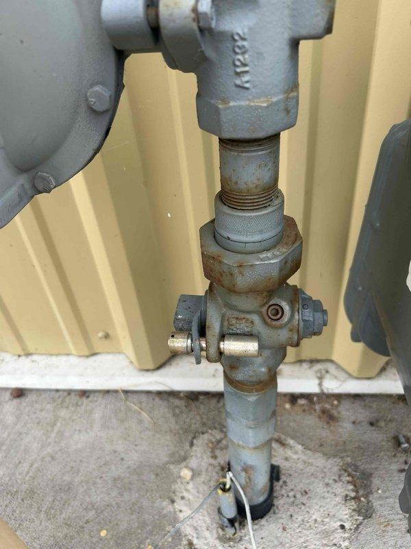 Responded to gas leak emergency at commercial facility where utility company had tagged out gas meter and identified tube heaters in shop area as probable leak source. Conducted initial site assessment and inspected multiple overhead tube heating units and gas piping system. Observed corroded pipe fittings and connections at gas supply lines showing visible oxidation and rust accumulation. Determined that proper leak isolation testing would require scissor lift access to reach elevated tube heaters and coordination to relocate fire apparatus for adequate workspace clearance. Verified one-inch gas supply line at meter location. Documented existing conditions with photographs showing overhead equipment placement, ceiling-mounted heating units, and deteriorated gas piping connections. Consulted with facility contact regarding age of existing tube heater system and discussed testing procedures required to pinpoint specific leak location. Scheduled follow-up service appointment to perform p