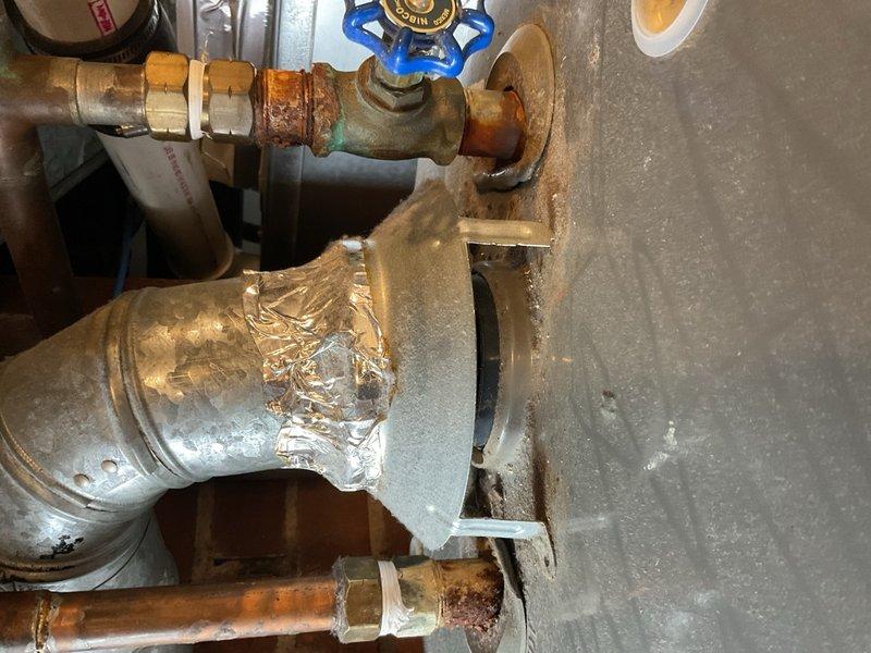 Responded to A/C repair callback on 1996 Goodman air conditioning system. Previous technician had replaced run capacitor, which restored operation temporarily, but unit failed again the same night. Upon arrival, found condenser fan motor locked up. Tested capacitor and confirmed within specification. Checked fan motor windings and measured approximately 100–250 ohms, indicating motor failure. Identified severe crimp in suction line between indoor and outdoor units, which restricts refrigerant flow and contributes to poor system performance. Given the age of the equipment (27 years old) and multiple component failures, recommended system replacement evaluation. Comfort advisor scheduled to provide replacement quote. During inspection, also observed leaking CPVC plumbing requiring attention. Plumbing advisor scheduled for separate quote on piping repairs. Documented conditions with photographs showing corroded plumbing components and mechanical space configuration.