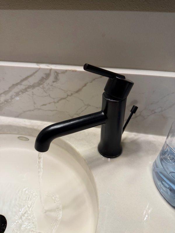 Completed comprehensive plumbing inspection of residential property focusing on reported leaking pipes extending from master bathroom to basement level. Inspected exposed PVC drainage piping system in utility area, examining multiple elbow joints, vertical and horizontal pipe runs, and connection points for signs of leaks or deterioration. Evaluated master bathroom plumbing fixtures including sink, faucet assembly, and associated supply lines for proper operation and potential water intrusion issues.