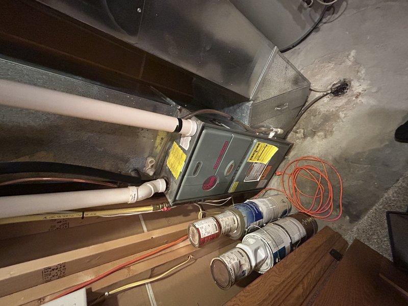 Responded to no cooling complaint on approximately 20-year-old Rheem unit utilizing R-22 refrigerant. Upon inspection, found system operating with suction pressure at 23 psi, indicating significant refrigerant loss. Outdoor condenser coil extremely dirty, restricting airflow and reducing system efficiency. Diagnosed refrigerant leak requiring repair. Documented attic-mounted air handler installation and filter condition with photos. Provided customer with repair options including refrigerant recharge and leak repair versus system replacement given age of equipment and R-22 phase-out considerations.