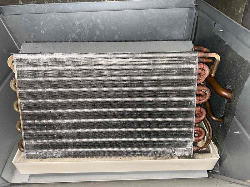 Completed annual cooling maintenance on 24-year-old Amana HVAC system as part of Family Rewards agreement. Performed comprehensive AC tune-up including inspection of evaporator coil, which showed dust and debris accumulation on fins with visible oxidation on refrigerant lines consistent with system age. Verified refrigerant line connections, checked condensate drainage system, and inspected furnace cabinet and associated PVC venting. All components functioning within normal parameters with no current issues identified by customer or during inspection.