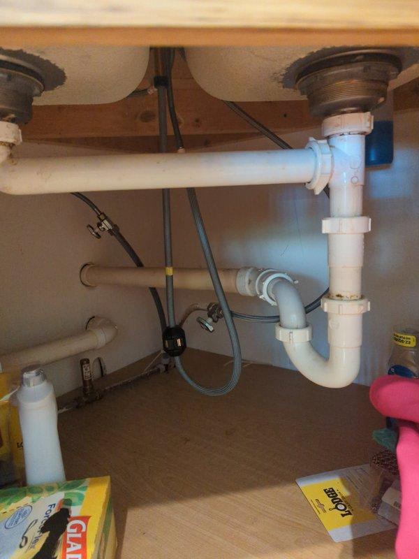 Completed installation of customer-supplied InSinkErator Power 1.0HP garbage disposal unit with 3D Grind Plus technology. Connected disposal to existing drain system using white PVC P-trap assembly and verified proper alignment with dual sink configuration. All connections tested and confirmed operational with no leaks detected.