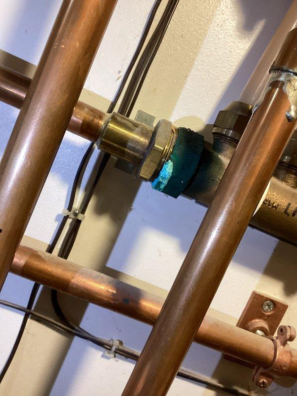 Responded to service call for boiler safety inspection and water coil replacement. Upon inspection, identified severely corroded and rusted-through water coil with visible oxidation and verdigris formation on copper piping and fittings. Removed failed water coil and replaced with new unit. Inspected heat exchanger for safety concerns and verified proper operation. Secured all plumbing connections and tested system for leaks. System restored to full operational status.