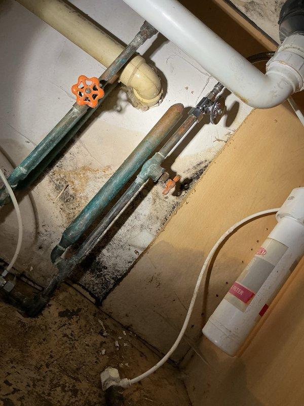 Responded to emergency call for burst pipe under kitchen sink. Upon inspection, discovered the drinking water filter was leaking and had caused significant water damage, with the sink base cabinet completely rotted out from prolonged moisture exposure. Disconnected the drinking water faucet assembly and installed new shut-off valve on the cold water supply line. Replaced deteriorated supply line to cold side of kitchen faucet and tested all connections. Verified no leaks present after repairs and system restored to full operation.