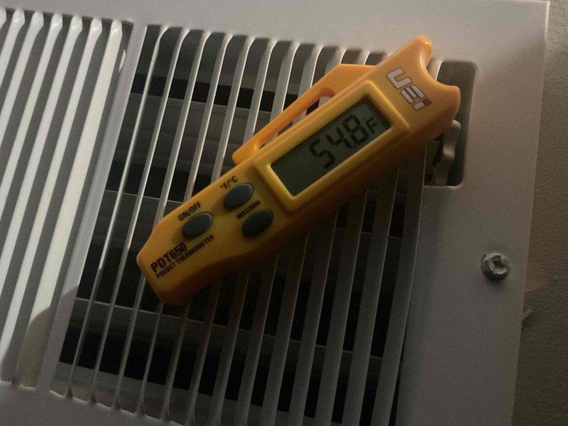 Responded to airflow concerns and performed comprehensive ductwork inspection using camera scope to identify potential blockages. Investigated hidden dampers concealed above ceiling tiles, opened closed dampers to restore proper airflow, and measured supply air temperatures at multiple registers, recording readings of 54.6°F and 59.8°F to verify system performance after adjustments.