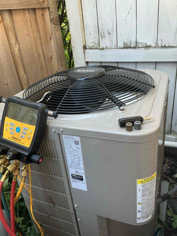 Responded to no cooling complaint on Bryant air conditioning system. Upon arrival, discovered condensate drain line from indoor head unit was completely disconnected, causing water drainage issues. Attempted reconnection but found the plastic fitting was crushed and unable to properly seal water into the vinyl tube. Temporarily pitched condensate line away from house to prevent water damage. Performed annual cooling maintenance visit including system inspection and testing. Connected manifold gauges to outdoor condensing unit to verify refrigerant pressures and system operation. Submitted parts order request for condensate line replacement from indoor head unit. Restored power to system and turned thermostat to cooling mode to verify compressor and fan operation.