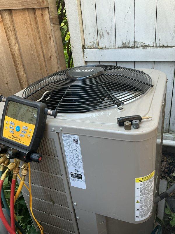 Responded to no cooling complaint on Bryant air conditioning system. Upon arrival, discovered condensate drain line from indoor head unit was completely disconnected, causing water drainage issues. Attempted reconnection but found the plastic fitting was crushed and unable to properly seal water into the vinyl tube. Temporarily pitched condensate line away from house to prevent water damage. Performed annual cooling maintenance visit including system inspection and testing. Connected manifold gauges to outdoor condensing unit to verify refrigerant pressures and system operation. Submitted parts order request for condensate line replacement from indoor head unit. Restored power to system and turned thermostat to cooling mode to verify compressor and fan operation.