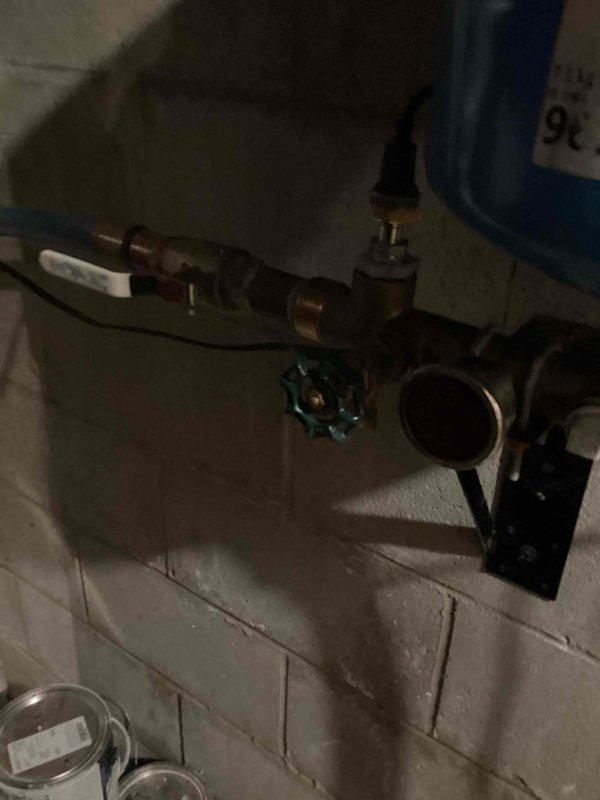 Responded to service call for non-functioning water softener in basement utility area. Upon inspection, determined that the electronic display unit was inoperative and the motherboard was malfunctioning. Documented equipment condition with photographs showing the water softener tank with control unit and surrounding plumbing connections. Advised property contact that repair options include full softener replacement or coordination with North Star for motherboard repair.