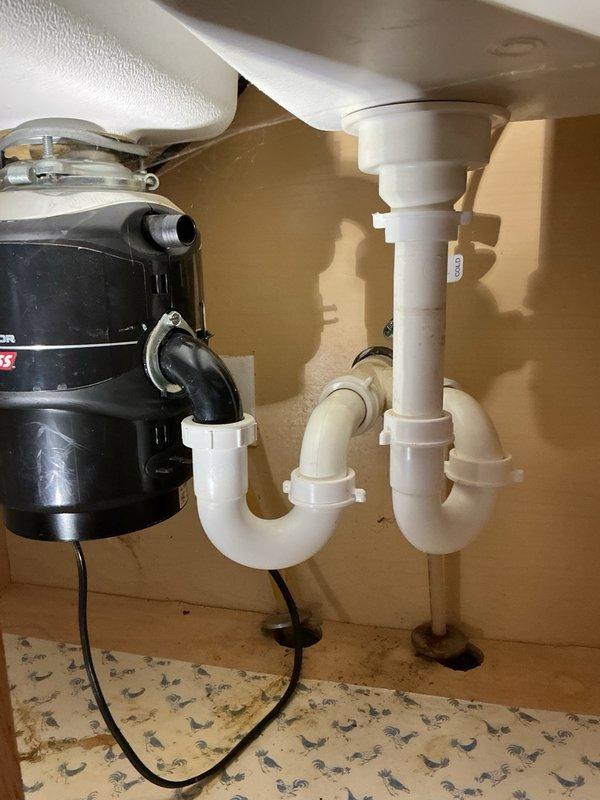 Conducted site assessment for kitchen sink replacement project. Customer currently has dual-hole sink configuration and wishes to convert to single-hole sink setup. Took measurements of existing sink basin and documented current plumbing configuration, including garbage disposal unit on left side and white PVC drain assembly with P-trap on right side. Provided estimate for complete sink replacement and re-piping of drain assembly beneath sink. Customer will source preferred sink unit from local supplier and schedule installation upon acquisition. Future scope of work will include removal of existing dual-hole sink, installation of new single-hole sink, modification of drain plumbing to accommodate new configuration, and reconnection of garbage disposal unit to updated drain system.