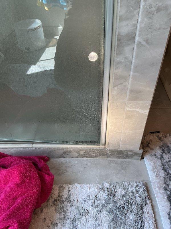 Responded to water leak complaint with visible ceiling damage in kitchen area directly below master bathroom shower. Upon investigation, determined leak was isolated to shower usage only. Inspection revealed improperly closing shower door allowing water to escape containment area, run down shower curb, and accumulate on tile floor. Water penetration occurred through grout lines and substrate, migrating to ceiling below. Performed exploratory opening in kitchen ceiling to confirm moisture source and verify water damage location corresponded with shower curb position. Documented conditions with photographic evidence showing ceiling water staining and bathroom floor conditions including moisture accumulation near shower door track. Advised property owner that shower door requires adjustment or replacement to establish proper seal and prevent continued water escape. No plumbing system defects identified; issue attributed solely to shower enclosure door malfunction allowing water bypass dur