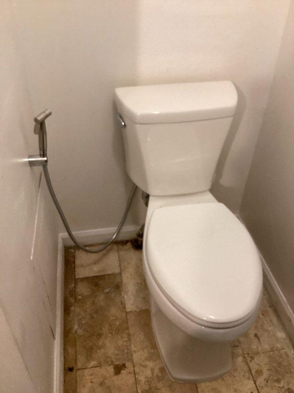 Removed and replaced defective toilet with new Gerber Viper elongated standard height model. Installed customer-supplied handheld bidet sprayer with wall-mount bracket and connected flexible supply line to water source. All connections tested and verified leak-free upon completion.