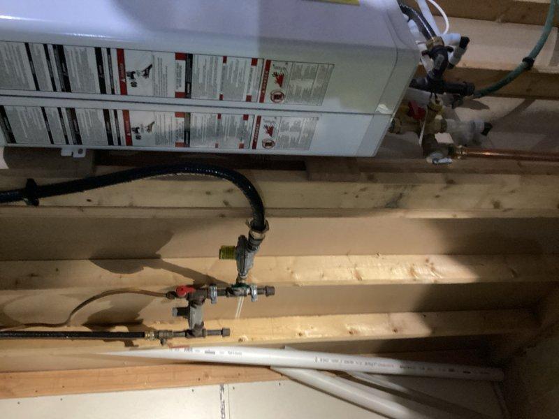 Responded to emergency call for gas leak at recently installed tanked water heater. Upon arrival, identified loose GasTite fitting on gas supply line to water heater as source of leak. Tightened the compromised fitting and performed thorough leak detection test on all gas connections using approved methods. Verified complete repair with no residual leaks detected at water heater gas supply connections or surrounding fittings. Documented installation with photographs showing water heater, plumbing connections, and gas line assembly for service records.