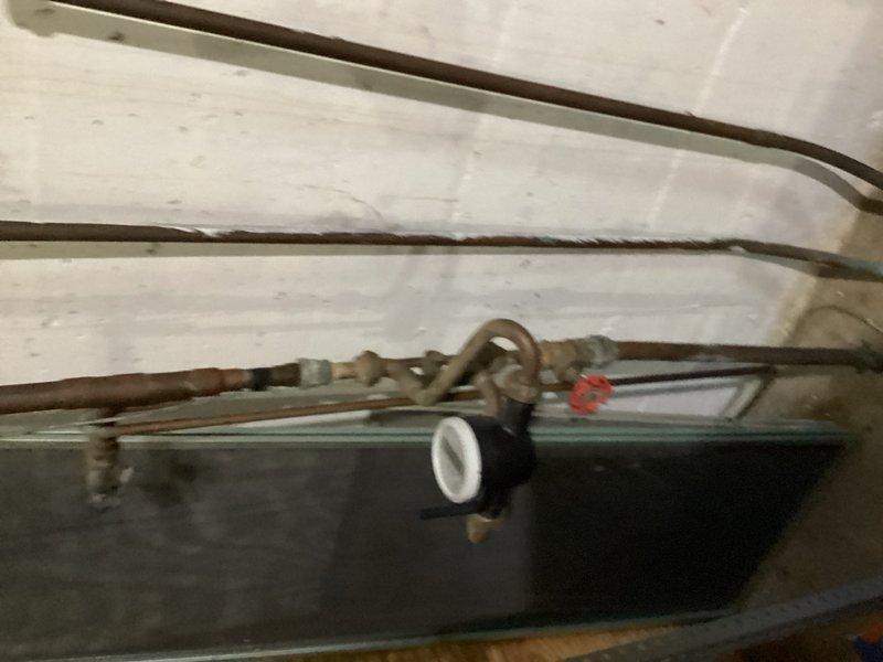 Responded to emergency call for gas leak at recently installed tanked water heater. Upon arrival, identified loose GasTite fitting on gas supply line to water heater as source of leak. Tightened the compromised fitting and performed thorough leak detection test on all gas connections using approved methods. Verified complete repair with no residual leaks detected at water heater gas supply connections or surrounding fittings. Documented installation with photographs showing water heater, plumbing connections, and gas line assembly for service records.