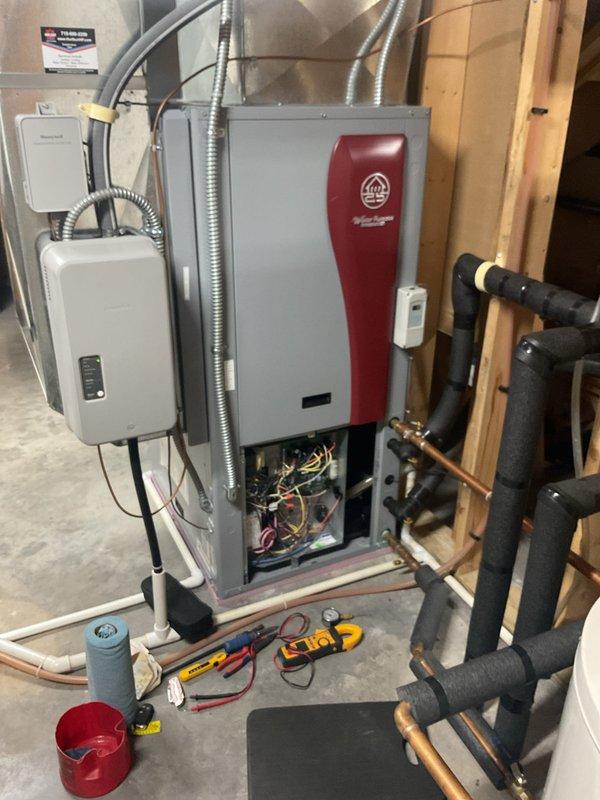 Completed comprehensive maintenance tune-up on 7-month-old geothermal heat pump system with in-floor heating zones. Verified operation of geothermal unit, measured loop and load side pressures and temperatures with satisfactory 20-degree temperature differential across system. Tested capacitor reading 27.5 microfarads, slightly below rated 30 microfarads but within acceptable operating range. Inspected and confirmed proper operation of all zone valves controlling in-floor radiant heating system. Performed standard preventive maintenance procedures per agreement requirements, including visual inspection of mechanical room equipment, water heater connections, pressure tank, and associated plumbing components.