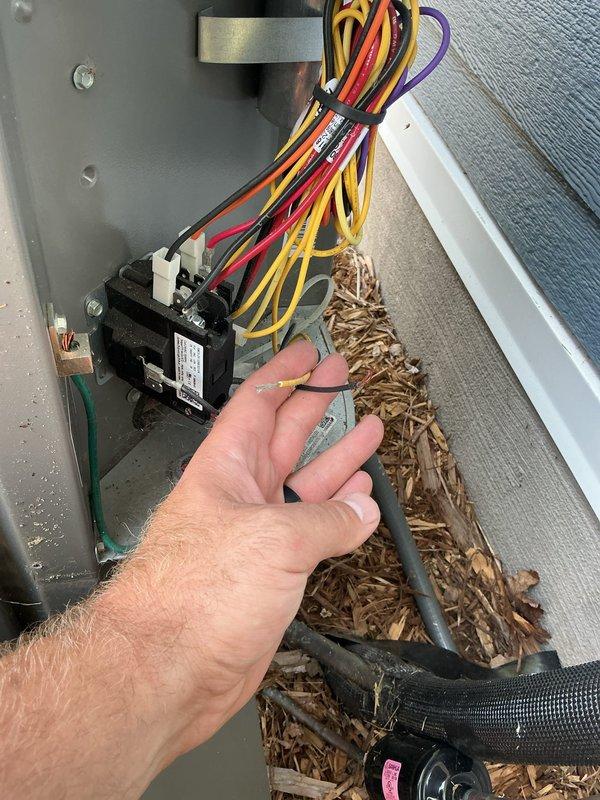 Responded to no-cool service call and discovered A/C unit completely non-operational due to missing or disconnected control wiring. Upon inspection, found the fan wire disconnected from the furnace and the 2-wire communication cable between the outdoor condenser and indoor air handler either removed or never properly installed. Additionally identified missing or improperly installed 4-wire thermostat wiring from basement to furnace. Documented wiring deficiencies with photographs showing debris accumulation in furnace cabinet and crawl space conditions where new wiring will need to be fished. Prepared estimate for running new 2-wire from outdoor unit across ceiling to furnace and installing new 4-wire thermostat cable, coordinating with electrician for wire fishing and installation to restore system functionality and enable operational testing.