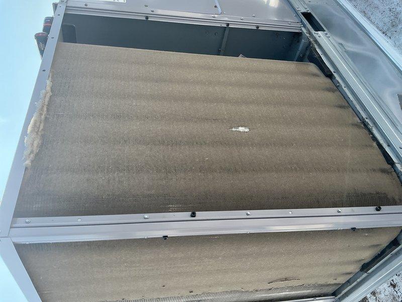 Completed annual cooling maintenance on two commercial rooftop units. Replaced twelve 20x25x2 return air filters. Found one unit's condenser coil heavily clogged with cottonwood debris, restricting airflow; thoroughly cleaned and restored proper airflow. Second unit's coil was in good condition. Performed comprehensive inspection on both units including electrical connections, load and control voltages, motor amp draws verified against full load ratings, and economizer function testing. Inspected cooling circuits and checked refrigerant levels—all within normal operating parameters. Verified fan motors, capacitors, and control boards functioning properly. Cleaned condensate drain pans and traps. Inspected belts and pulleys for wear. Both systems tested and operating efficiently for continued cooling season operation.