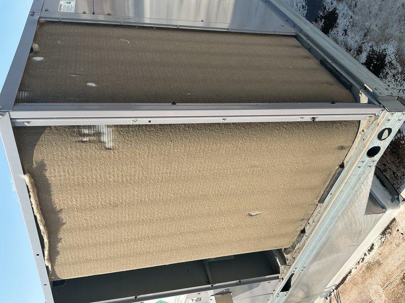 Completed annual cooling maintenance on two commercial rooftop units. Replaced twelve 20x25x2 return air filters. Found one unit's condenser coil heavily clogged with cottonwood debris, restricting airflow; thoroughly cleaned and restored proper airflow. Second unit's coil was in good condition. Performed comprehensive inspection on both units including electrical connections, load and control voltages, motor amp draws verified against full load ratings, and economizer function testing. Inspected cooling circuits and checked refrigerant levels—all within normal operating parameters. Verified fan motors, capacitors, and control boards functioning properly. Cleaned condensate drain pans and traps. Inspected belts and pulleys for wear. Both systems tested and operating efficiently for continued cooling season operation.
