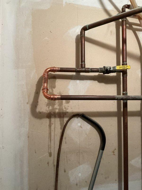 Responded to water softener leak in mechanical room. Upon inspection, determined the existing water softener unit was deteriorated beyond repair and actively leaking. Per homeowner's request to not replace the softener, removed the failed unit from the plumbing system. Cut out the old water softener assembly and installed 90-degree copper elbows to reconnect the supply and return lines, bypassing the softener location entirely. Restored water service to the residence and verified proper flow with no leaks at the new connections.