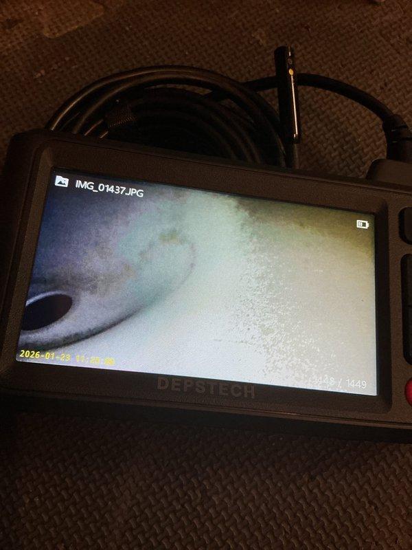 Responded to no cooling complaint on 20-year-old air conditioning system that had previously iced over. Upon arrival, unit was thawed and operational but failing to reach desired temperature setpoint. Performed diagnostic evaluation and identified system was low on R22 refrigerant. Conducted borescope inspection of evaporator coil, documenting interior condition with digital imaging that revealed moisture accumulation and oxidation staining on coil surfaces. Given the age of the unit, obsolete refrigerant type, and current system condition, recommended comfort advisor consultation for replacement options rather than repair of aging equipment.