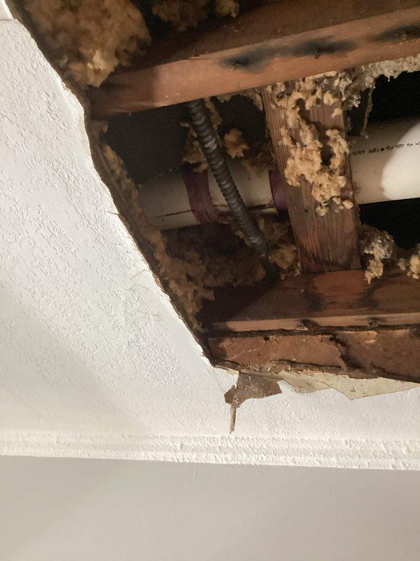 Responded to a ceiling leak caused by a failed roof drain coupling on a PVC drain pipe system servicing a flat roof. Upon inspection, water damage was evident in the interior ceiling with visible staining and deterioration of building materials. Disassembled the compromised roof drain coupling, properly cleaned and re-primed all mating surfaces, and reinstalled the coupling with PVC solvent cement applied to full depth to ensure a watertight seal and prevent future leakage.