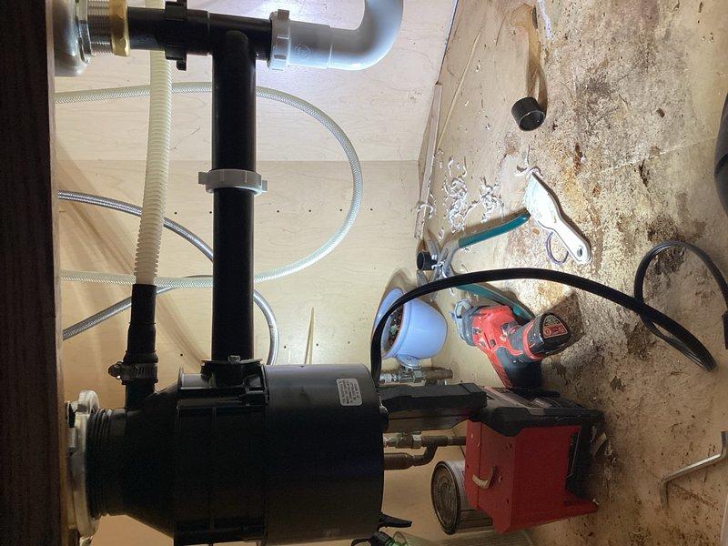 Responded to service call for malfunctioning garbage disposal unit. Upon inspection, determined existing disposal was inoperative and beyond repair. Identified improper drainage angle in undersink plumbing with back-pitched configuration causing water flow issues. Removed failed garbage disposal unit and installed new 3/4 HP replacement model. Completely reconfigured and reinstalled all undersink plumbing to correct drainage pitch and ensure proper water flow. Tested system operation and verified proper drainage function upon completion.