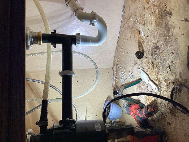 Responded to service call for malfunctioning garbage disposal unit. Upon inspection, determined existing disposal was inoperative and beyond repair. Identified improper drainage angle in undersink plumbing with back-pitched configuration causing water flow issues. Removed failed garbage disposal unit and installed new 3/4 HP replacement model. Completely reconfigured and reinstalled all undersink plumbing to correct drainage pitch and ensure proper water flow. Tested system operation and verified proper drainage function upon completion.