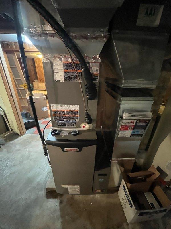Completed full HVAC system installation including relocation of outdoor AC unit to side yard directly outside mechanical room with venting routed through north side of home. Installed EL297V 97% AFUE two-stage variable speed upflow furnace (70K BTU) as indoor unit, paired with EL18KCV inverter-driven 18 SEER2 two-stage 3-ton air conditioner as outdoor unit, and cased B-frame evaporator coil (3-ton) with factory-installed TXV valve. Installation included new chimney venting system with custom-fabricated chimney cap, programming and setup of three room sensors for zoned temperature control, complete refrigerant line sets, condensate drainage system with pump, electrical connections, and full ductwork integration. System tested, verified operational performance across all stages, and confirmed proper communication between all components.
