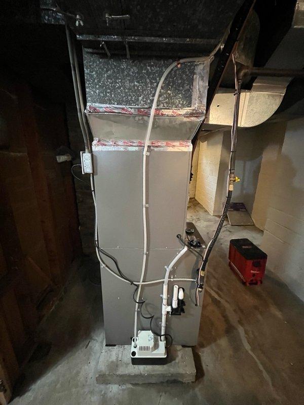 Completed full HVAC system installation including relocation of outdoor AC unit to side yard directly outside mechanical room with venting routed through north side of home. Installed EL297V 97% AFUE two-stage variable speed upflow furnace (70K BTU) as indoor unit, paired with EL18KCV inverter-driven 18 SEER2 two-stage 3-ton air conditioner as outdoor unit, and cased B-frame evaporator coil (3-ton) with factory-installed TXV valve. Installation included new chimney venting system with custom-fabricated chimney cap, programming and setup of three room sensors for zoned temperature control, complete refrigerant line sets, condensate drainage system with pump, electrical connections, and full ductwork integration. System tested, verified operational performance across all stages, and confirmed proper communication between all components.
