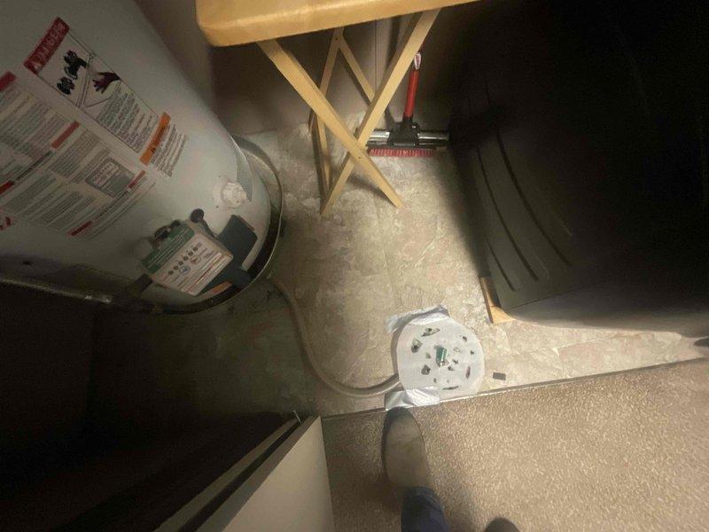 Completed plumbing inspection of residential water heater located in utility closet. Unit exhibited active leaking from bottom section, consistent with age-related tank deterioration and sediment buildup. Documented condition with photographs showing water heater installation, surrounding area, and evidence of leak source for customer records and replacement recommendations.