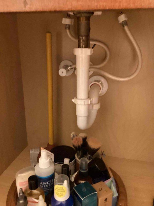 Responded to service call for clogged bathroom sink and leaking toilet in powder room. Inspected toilet and identified active leak at base of fixture where it meets the floor, indicating failed wax ring seal. Assessed sink drain system and P-trap assembly beneath vanity cabinet. Provided estimate for complete toilet replacement due to compromised base seal. Documented existing conditions with photographs of affected fixtures for customer review.