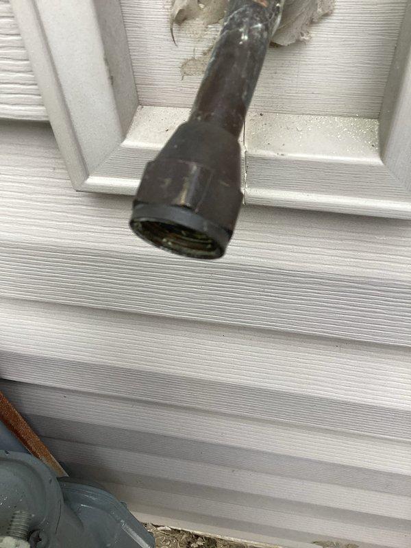 Completed code correction work for tankless water heater installation requiring gas line upsizing and concentric venting modifications. Installed new 1/2" soft copper gas line running approximately 80 feet from the meter along exterior siding into the mechanical room, replacing undersized 3/8" line. Added dedicated regulator positioned 10 feet from tankless unit and connected heater to its own gas supply line. Capped off original 1/2" black iron tee connection point. Modified concentric vent kit by snorkeling exhaust side 3 feet above furnace intake to meet code clearance requirements. Secured all new gas piping to structure, applied high-pressure warning labels at appropriate locations, and performed complete leak check of all connections. System tested and verified operational with no leaks detected. Unit left in service.