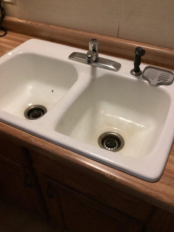 Completed routine plumbing inspection of residential kitchen fixtures and components. Inspected double-basin kitchen sink, single-handle chrome faucet assembly, spray nozzle attachment, drain assemblies with strainer baskets, and soap dispenser for proper operation and potential issues. All fixtures found to be functioning within normal parameters with no immediate repairs required at time of inspection.