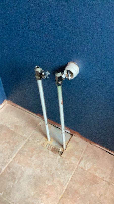Installed two chrome angle stop shut-off valves with compression fittings on water supply lines serving bathroom vanity. The valves were mounted on vertical pipes emerging from the floor against the wall, providing individual water control for hot and cold supply lines. Installation included proper compression fitting connections to ensure leak-free operation.