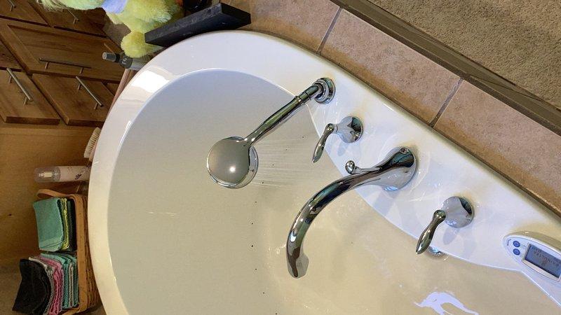 Responded to service call for malfunctioning tub filler diverter. Removed existing tub faucet and filler valve that was no longer diverting water properly. Cut access opening in basement ceiling drywall below the tub to reach plumbing connections. Installed new chrome tub filler valve and faucet assembly. Installed access panel in ceiling for future maintenance access. Tested all fixtures for proper water flow and diverter operation upon completion.