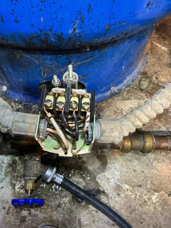 Responded to service call for low water pressure issue on well system. Upon inspection, diagnosed faulty pressure switch as the cause of inadequate water pressure. Replaced defective pressure switch with new unit, restored proper electrical connections to terminal block, and verified system operation. Photographed completed installation showing new pressure switch mounted to pressure tank with proper wiring connections and plumbing components.