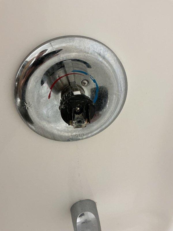 Responded to a callback for a Moen shower valve with a loose cartridge causing the handle to drift from the vertical position to full hot on its own, resulting in temperature fluctuations. Initially attempted replacement with a new cartridge, which exhibited the same issue due to excess factory grease on the internal barrel component. Resolved the problem by removing the barrel from the cartridge, wiping off the excess grease, and reinstalling, which restored proper friction and handle stability.
