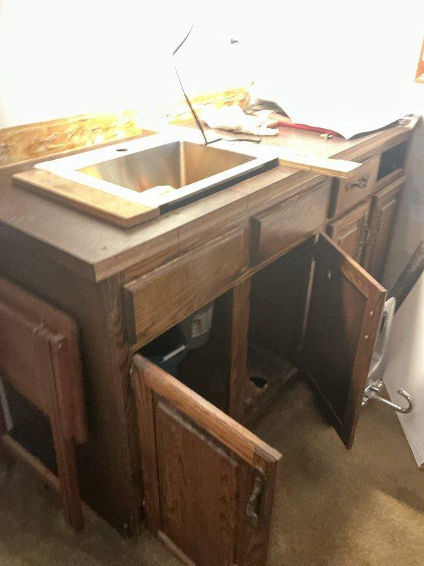 Conducted on-site assessment of kitchen sink plumbing system during active renovation. Inspected exposed ceiling cavity above work area, documenting vertical supply lines, pipe hangers, and structural supports for proper clearance and accessibility. Evaluated undermount double-basin sink installation with countertop removed, examining cabinet structure and plumbing connections beneath. Documented current conditions of water supply routing and drainage configuration to provide accurate estimate for faucet replacement and associated plumbing modifications required to complete kitchen renovation project.