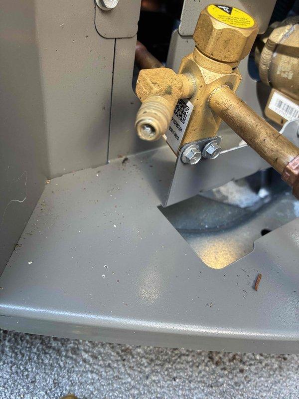 Responded to return visit for frozen air conditioning system approximately one year after installation. Connected manifold gauges and placed unit in charge mode to diagnose issue. Discovered severely leaking Schrader core on liquid line service port that was dripping refrigerant, which was replaced. Verified refrigerant charge levels were within proper range after core replacement. Adjusted airflow and dehumidification settings that had been modified during previous visit, which likely contributed to freezing condition. Recommended installing discharge air temperature sensor if freezing issues persist.
