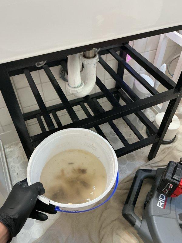 Responded to main floor bathroom drainage issues affecting both shower and sink fixtures. Removed significant accumulation of hair from bathtub drain and cleared heavy buildup of organic debris from bathroom sink drain. Performed thorough cleaning of both drain assemblies and conducted extensive water flow testing to verify proper drainage restoration and confirm blockages were completely eliminated.